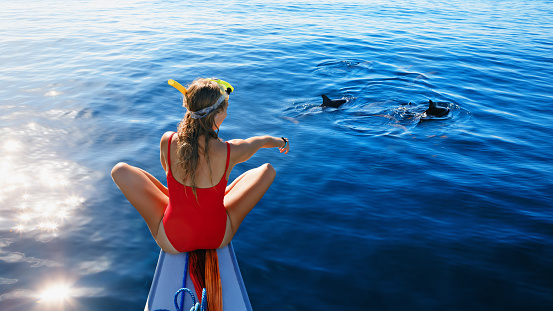 Young girl on dolphins watching and snorkeling tour