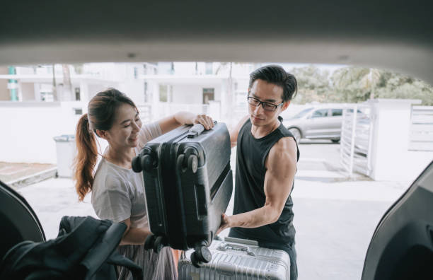 istock asian chinese couple getting ready loading luggage in their SUV going for vacation 1271285427