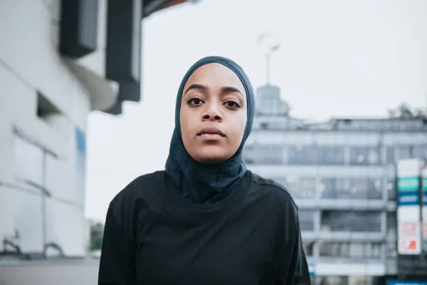 portrait of young muslim sports woman with hijab in front of Berlin cityscape