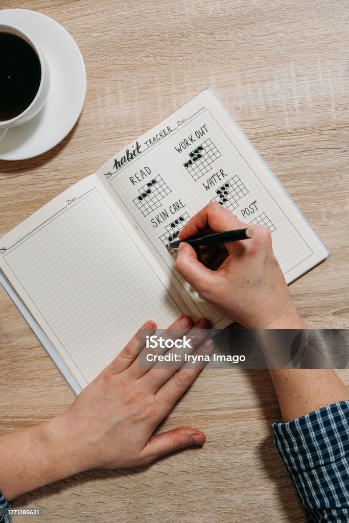 Bullet Journal Habit Tracker. Woman cross off day with routine in her Habit Tracker. Selective focus Bullet Journal Habit Tracker. Woman cross off day with routine in her Habit Tracker. Selective focus. Bullet Stock Photo