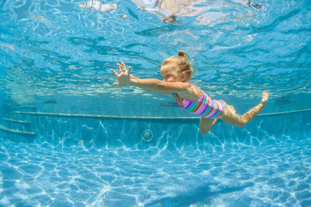 istock Happy child dive underwater with fun in swimming pool 1271285635