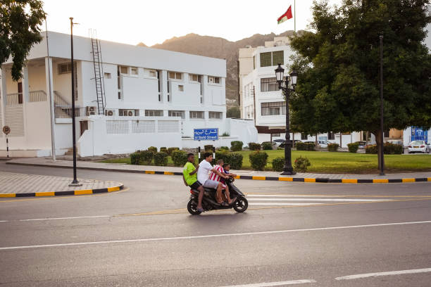 pai e três filhos andando de moto na capital de omã - acidente evento relacionado com o transporte - fotografias e filmes do acervo