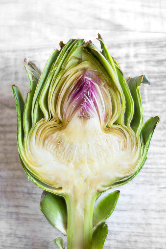 cross section of a baby artichoke on wooden table