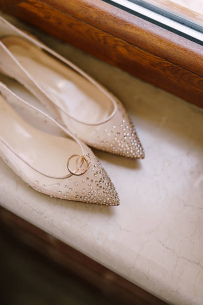 istock Wedding rings on the bride's ballet flats with beads on the windowsill. 1271290247