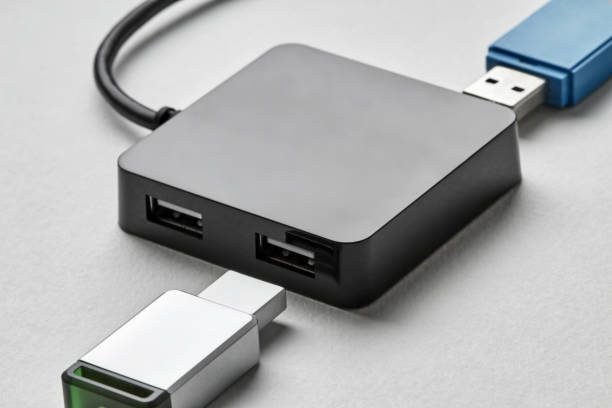 istock Black portable USB hub for four connections with usb flash drives on a white background. Bus povered. Closeup, selective focus 1271293092
