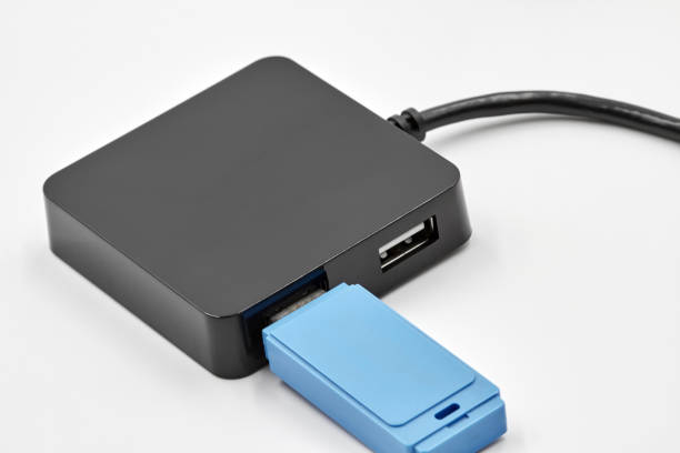 istock Black portable USB hub for four connections with usb flash drive on a white background. Bus povered. Closeup, selective focus 1271293111