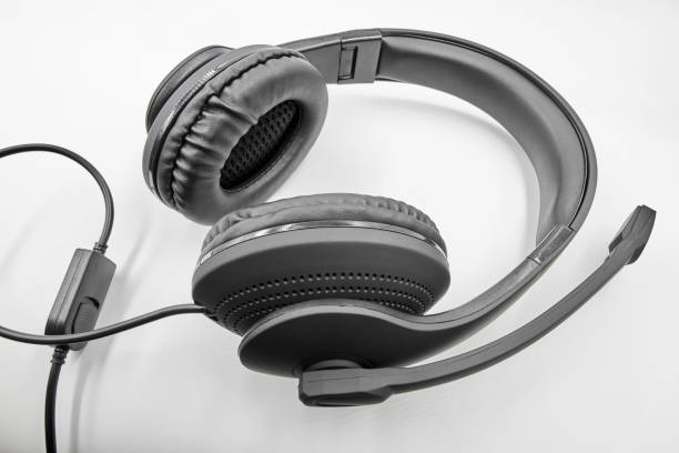istock Black headphones with microphone lie on white background. Closeup 1271293131