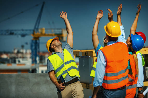 istock Group of contractors celebrating the end of successful construction process. 1271293931