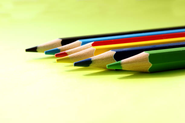 Colored pencils on a pink background. Lots of different colored pencils. Colorful pencil. Pencils are sharp. Pencils lie diagonally in lower left corner. Close-up. Copy space. Background. Flat lay.