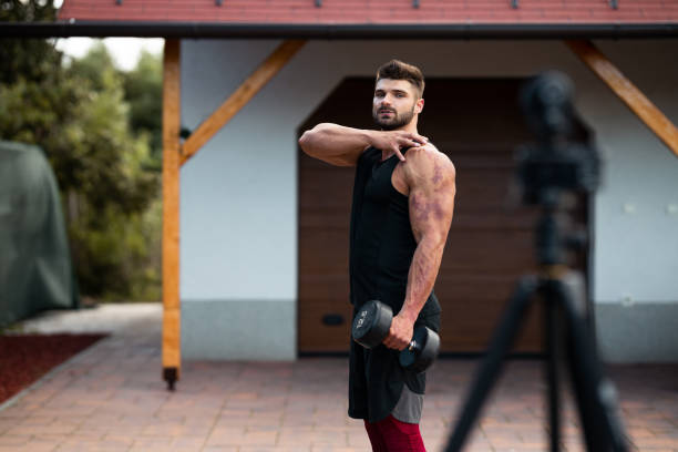 istock Male athlete doing exercise in backyard and filming vlog. 1271295365