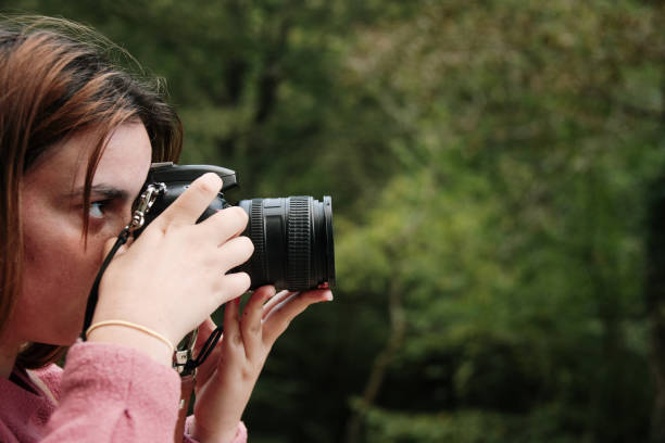 istock Young woman using a DSLR camera in a forest 1271295442