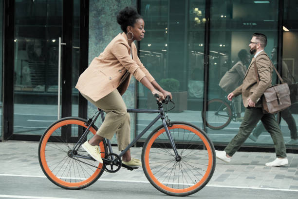 woman riding to work - walk cycle imagens e fotografias de stock