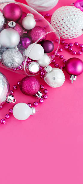 istock Christmas baubles in a wine glass on a pink background 1271298572