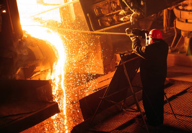 Plant for the production of steel. An electric melting furnace. Factory worker takes a sample for metal. Plant for the production of steel. An electric melting furnace. Factory worker takes a sample for metal slag heap stock pictures, royalty-free photos & images