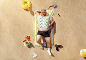 Funny overweight tourist getting tanned on the beach