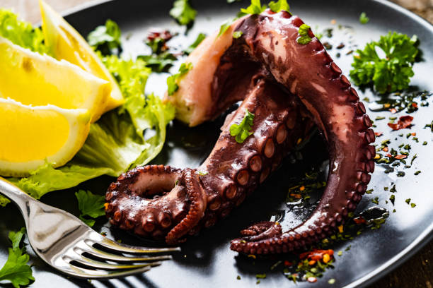 istock Boiled octopus and vegetables on wooden table 1271299931