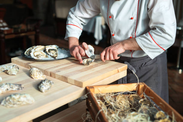 istock Opening the hollow and flat oysters. Chef opens oysters in the restaurant. 1271300496