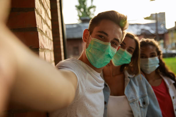 istock Friends in protective face masks taking selfie together 1271302322