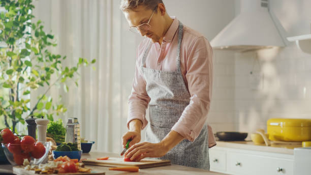 istock Shot of a Handsome Young Man Chopping a Green Chili Pepper with a Sharp Kitchen Knife. Preparing a Healthy Organic Salad Meal in a Modern Kitchen. Natural Clean Diet and Healthy Way of Life Concept. 1271303861
