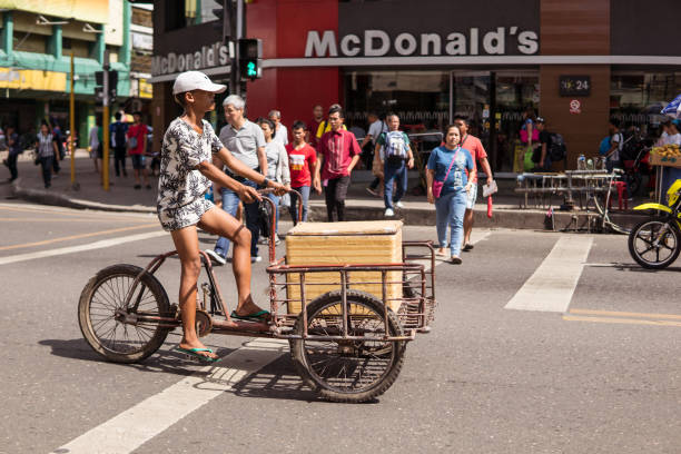 young Filipino man transporting container by tricycle on street in front of McDonalds Cebu / Philippines - July 10, 2019: young Filipino man transporting container by tricycle on street in front of McDonalds philippines tricycle stock pictures, royalty-free photos & images