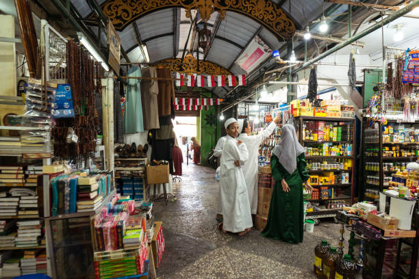 muslim kids in traditional white clothes in local covered bazaar - covered bazaar imagens e fotografias de stock