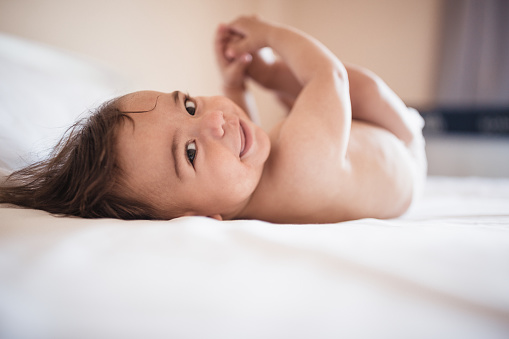 Baby boy portrait on a parents bed in the bedroom