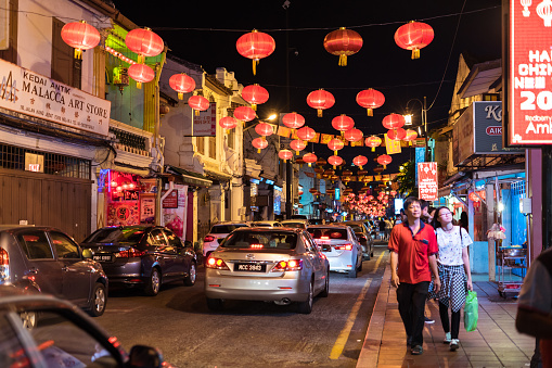 Malacca / Malaysia - February 16, 2019: group of tourists strolling the streets of Malacca with red lanters hanging over the street during Chinese New Year celebrations during night time