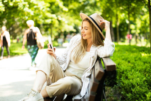istock Young blonde woman using phone in city park. 1271317832