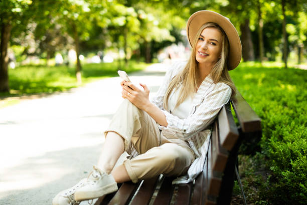 istock Young blonde woman using phone in city park. 1271317862
