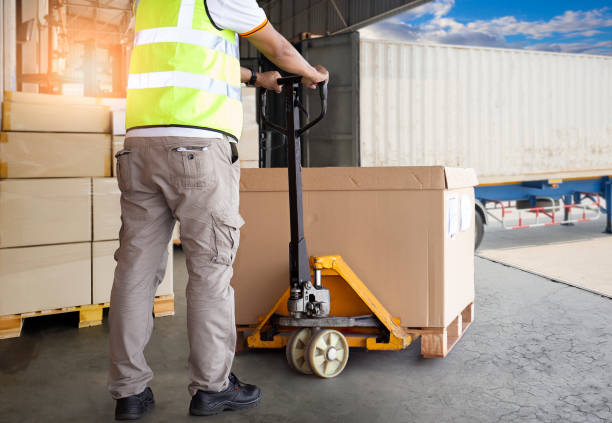 istock Cargo Shipment, Delivery, Freight truck transportation. Warehouse worker working with hand pallet truck loading a large box on pallet. 1271317940