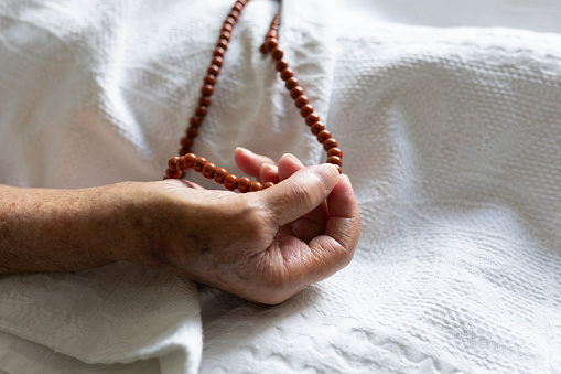 Muslim mature woman hand close up she holding prayer beads