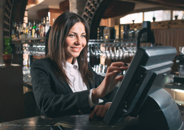 small business, people and service concept - happy woman or waiter or manager in apron at counter with cashbox working at bar small business, people and service concept - happy woman or waiter or manager in apron at counter with cashbox working at bar or coffee shop point of sale tablet stock pictures, royalty-free photos & images