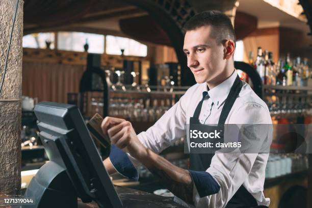 Small Business People And Service Concept Happy Man Or Waiter In Apron At Counter With Cashbox Working At Bar Or Coffee Shop Stock Photo - Download Image Now