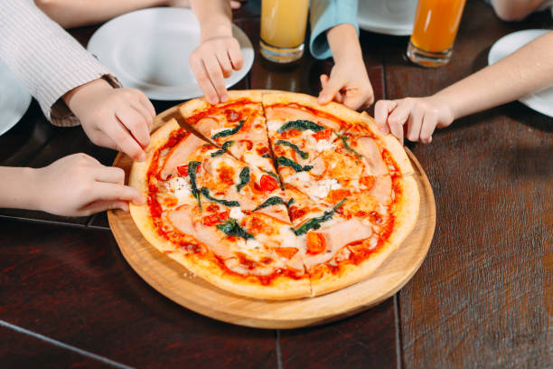 istock Hands taking pizza slices from wooden table, close up view 1271319566