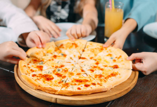 istock Hands taking pizza slices from wooden table, close up view 1271319596