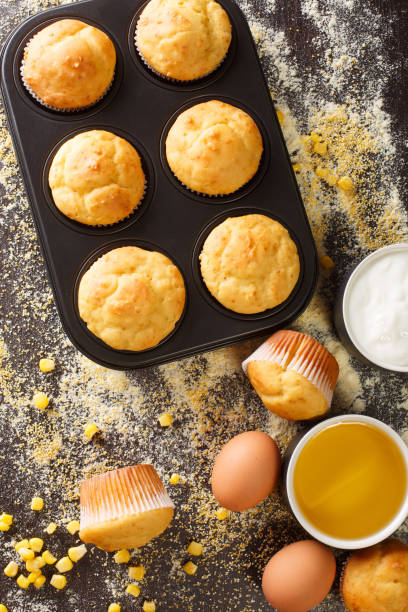 istock Freshly baked corn muffins in a baking dish and ingredients close-up. vertical top view 1271320606