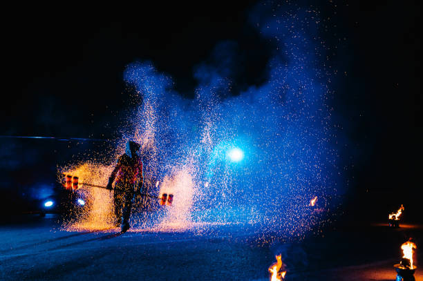 istock Fire show, dancing with flame, male master juggling with fireworks, performance outdoors, draws a fiery figure in the dark, bright sparks in the night. A man in a suit LED dances with fire. 1271322829