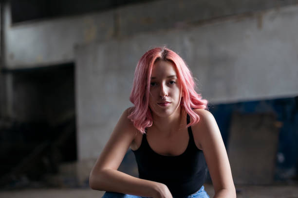 Young funky teenage girl with pink hair in abandoned building. stock photo