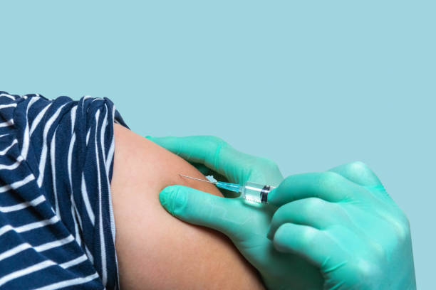 Doctor vaccinating woman in hospital stock photo