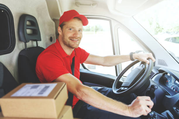 istock smiling delivery service man in red uniform driving van and delivering packages 1271329106