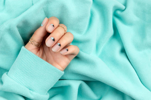 Beautiful groomed womans hand with nude and blue matte nail design. Beautiful groomed womans hand with nude and blue matte nail design. Manicure pedicure beauty salon concept. fall nail art stock pictures, royalty-free photos & images