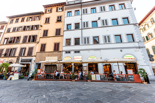 Firenze, Italy - August 30, 2018: Outside exterior of Florence cafe restaurant pizzeria in Tuscany with people sitting eating wide angle view of street and blue building