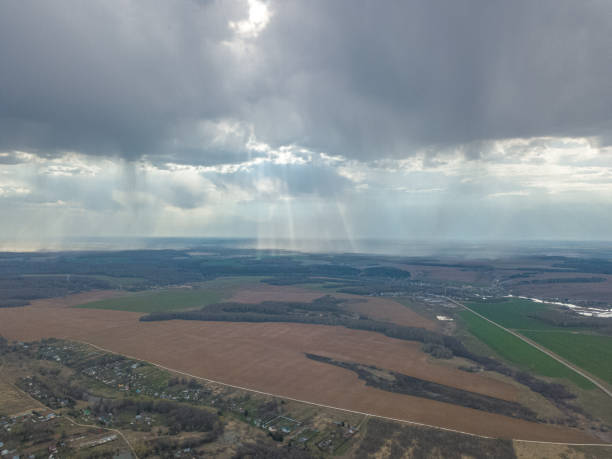 istock Dramatic sky with rain from clouds over pastoral rural landscape with agricultural fields, meadows and forests. 1271331750