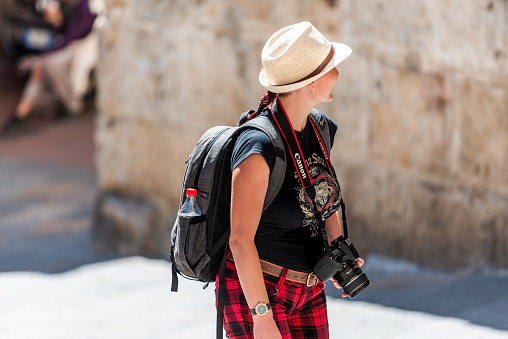 San Gimignano, Italy - August 27, 2018: City in Tuscany with tourist people young woman sightseeing on sunny summer day with camera photographer