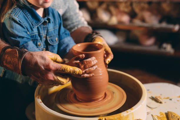 istock Pottery workshop. Grandpa teaches granddaughter pottery. Clay modeling 1271333950