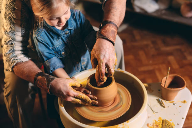 istock Pottery workshop. Grandpa teaches granddaughter pottery. Clay modeling 1271333995