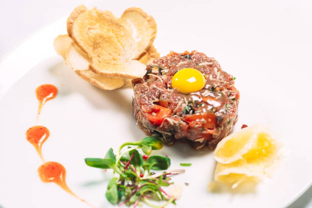 istock Tartar dish in the restaurant on a white plate on white background 1271334186
