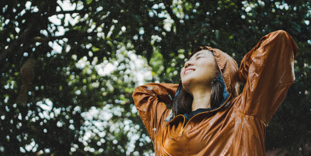 istock Asian women happy while it rains. She was outdoors in a park. 1271338682
