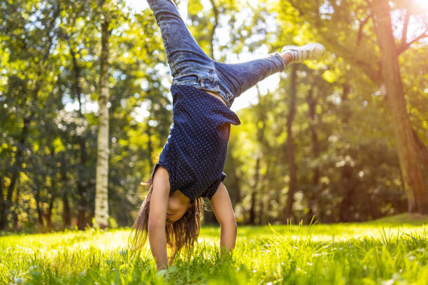 istock Child doing hand stand in park 1271340152