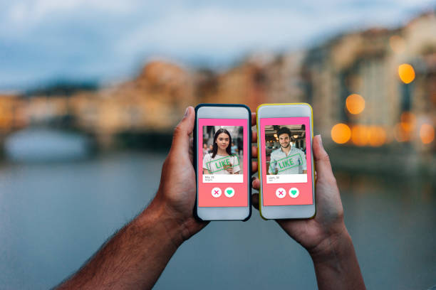 immagine concettuale di due mani che tengono gli smartphone con un'app di incontri online sullo schermo - appuntamento online foto e immagini stock